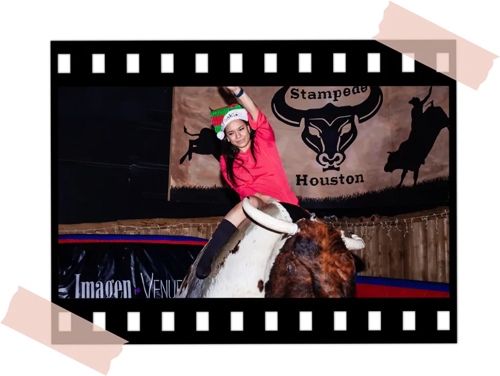 Team members competing on the mechanical bull at Imagen Venues Houston