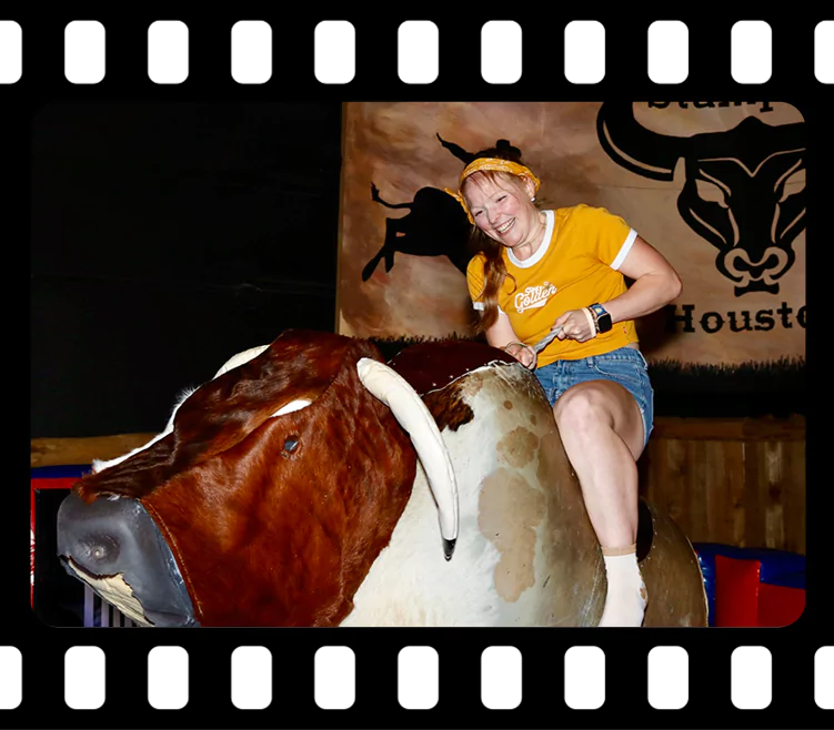 Employee riding mechanical bull at holiday party in Imagen Venues Houston