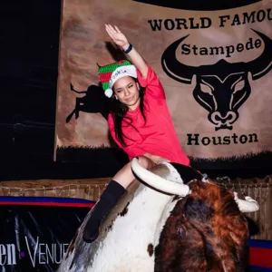 Guest riding the mechanical bull during a holiday party at Imagen Venues, a turn-key corporate event venue in Houston