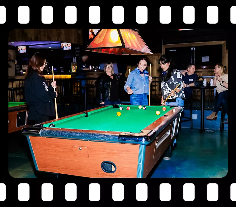 Group of guests playing pool and socializing in the entertainment area during a corporate event at Imagen Venues Houston
