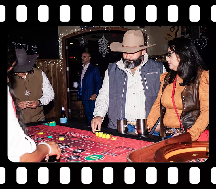 Guests placing chips at a roulette-style casino table during a corporate event at Imagen Venues Houston